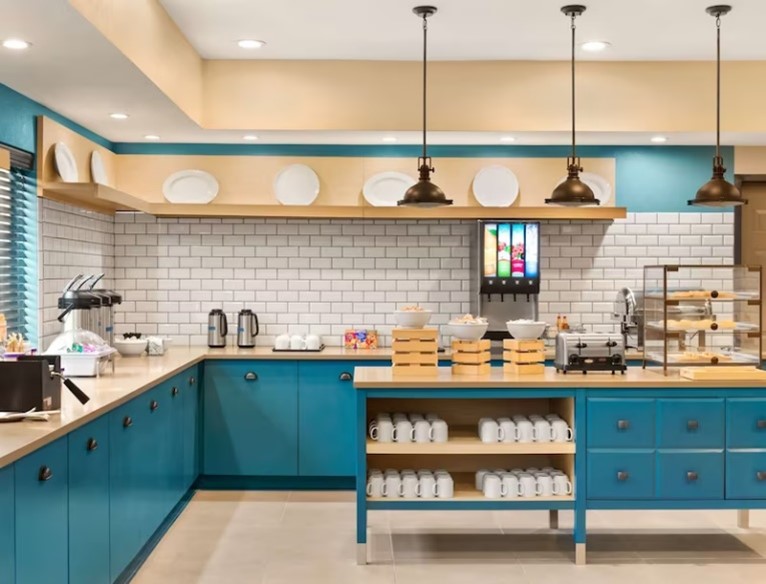 Kitchen with blue cabinets, hanging lights and open shelving